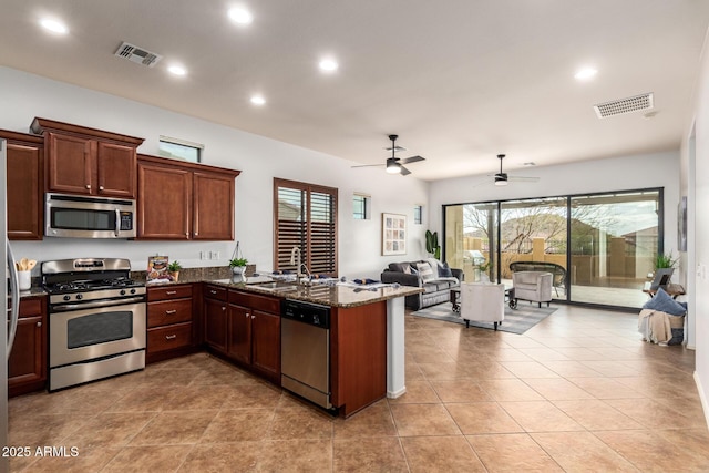 kitchen featuring open floor plan, visible vents, appliances with stainless steel finishes, and a sink