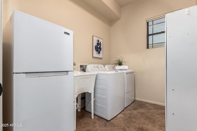 laundry room with washer and clothes dryer, laundry area, tile patterned floors, and baseboards