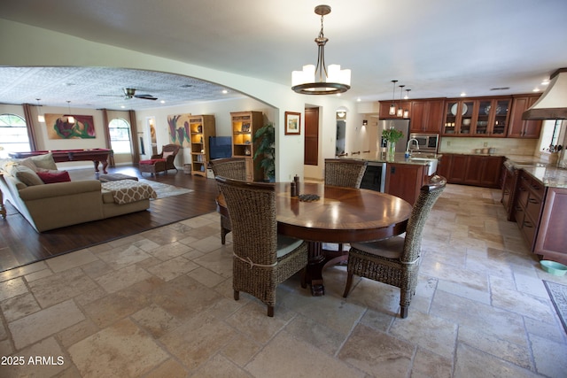 dining area with ceiling fan with notable chandelier and billiards