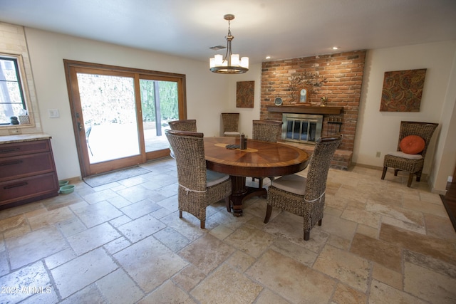 dining room featuring a chandelier and a fireplace