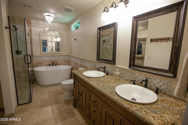 full bathroom with shower with separate bathtub, tile walls, vanity, and toilet