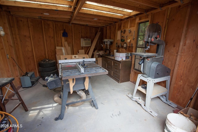 interior space featuring a workshop area, a wall mounted AC, and wood walls