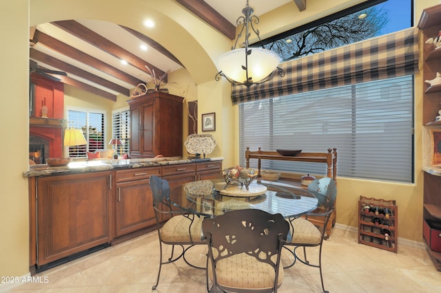 dining space featuring vaulted ceiling with beams