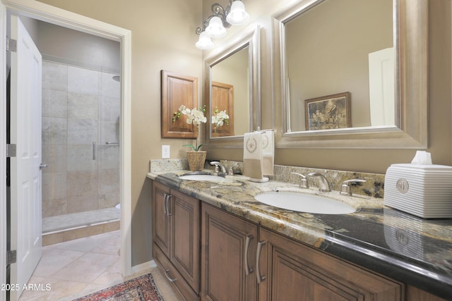 bathroom with tile patterned flooring, vanity, and tiled shower