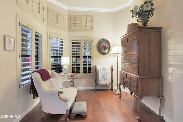 sitting room featuring wood-type flooring and ornamental molding