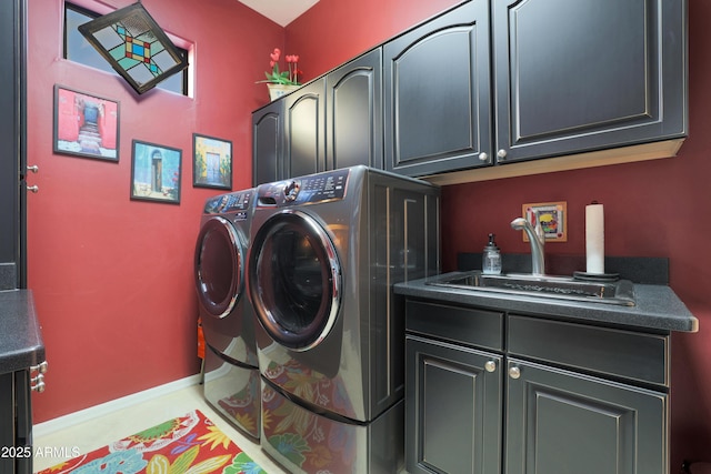 laundry area featuring washer and clothes dryer, cabinets, and sink