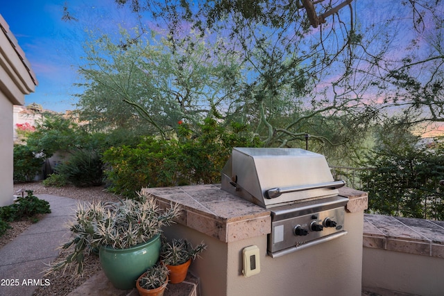 patio terrace at dusk featuring area for grilling