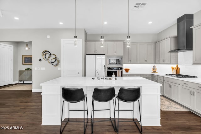 11233 N Blakely St, Surprise, AZ 85388 - kitchen with stainless steel appliances, wall chimney range hood, a breakfast bar, a sink, and recessed lighting