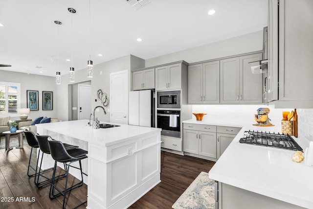 11233 N Blakely St, Surprise, AZ 85388 - kitchen with stainless steel appliances, a sink, gray cabinetry, dark wood-style floors, and open floor plan