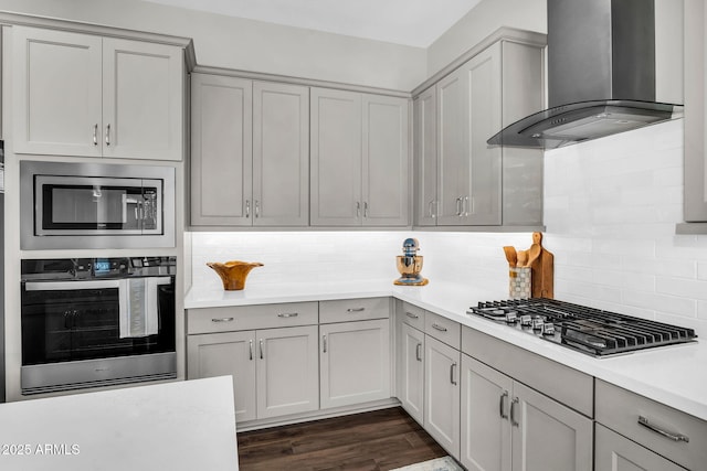 11233 N Blakely St, Surprise, AZ 85388 - kitchen with appliances with stainless steel finishes, wall chimney exhaust hood, light countertops, gray cabinetry, and backsplash