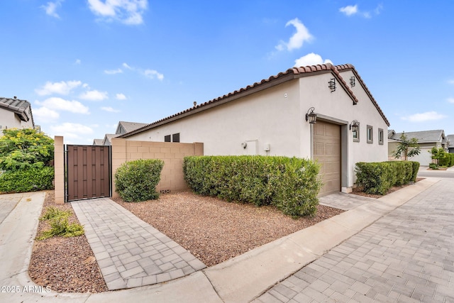 11233 N Blakely St, Surprise, AZ 85388 - view of home's exterior with an attached garage, stucco siding, driveway, and a gate