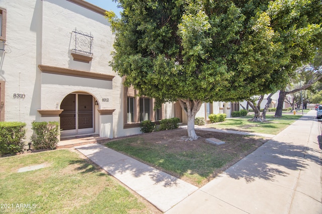 view of front of house featuring a balcony and a front yard