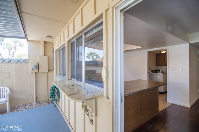kitchen with washing machine and clothes dryer, dark hardwood / wood-style floors, and a wealth of natural light