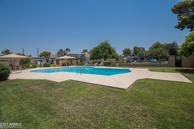 view of swimming pool with a patio and a lawn