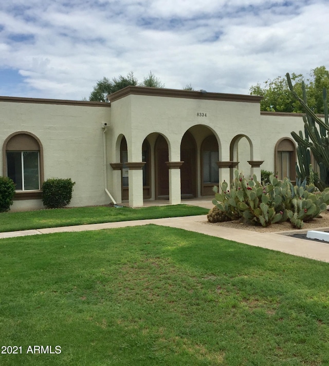 mediterranean / spanish house featuring a front lawn