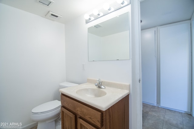 bathroom with toilet, tile floors, and vanity