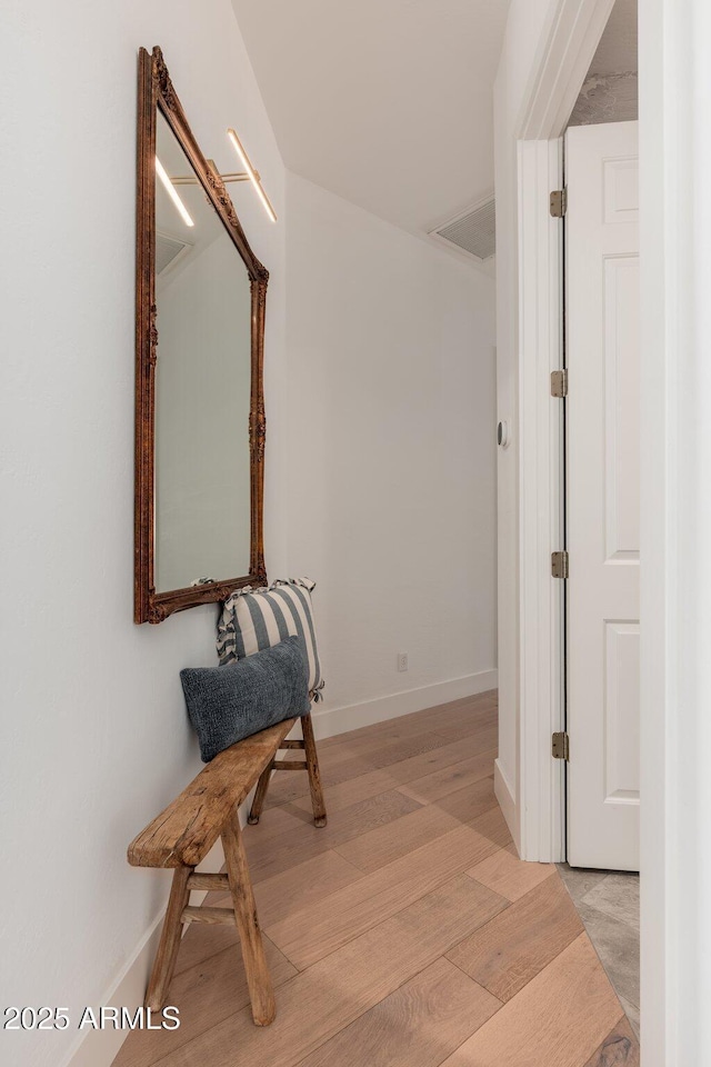 hallway featuring light wood-style flooring and baseboards