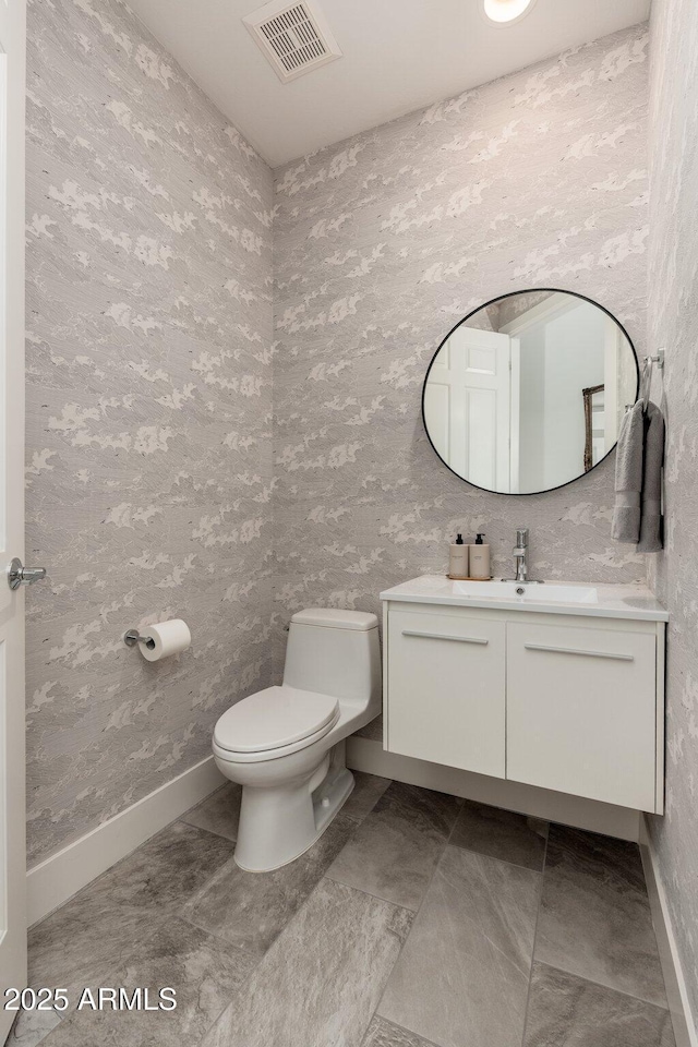 bathroom with baseboards, toilet, and vanity