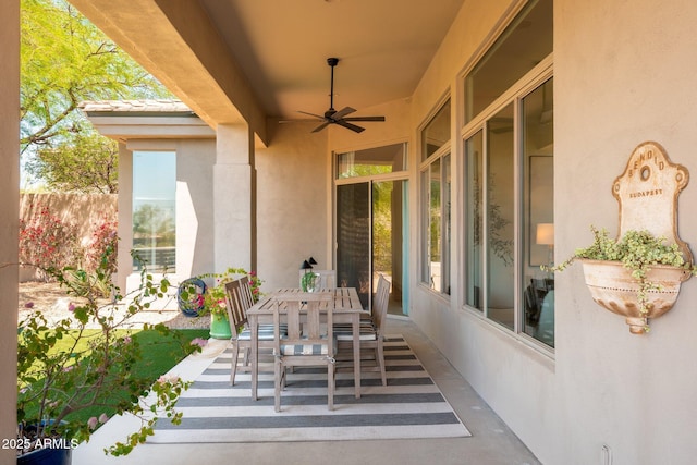 view of patio / terrace with a ceiling fan, outdoor dining space, and fence