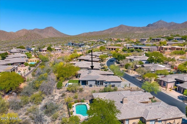 aerial perspective of suburban area featuring a mountainous background and a pool