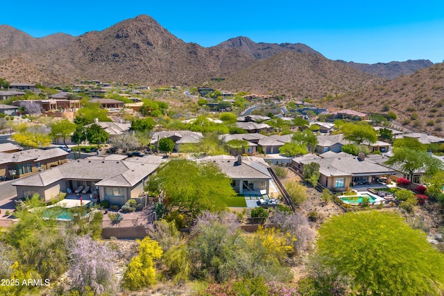 aerial perspective of suburban area featuring a mountain backdrop and a pool area