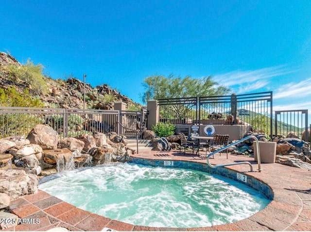 view of pool featuring fence and a community hot tub