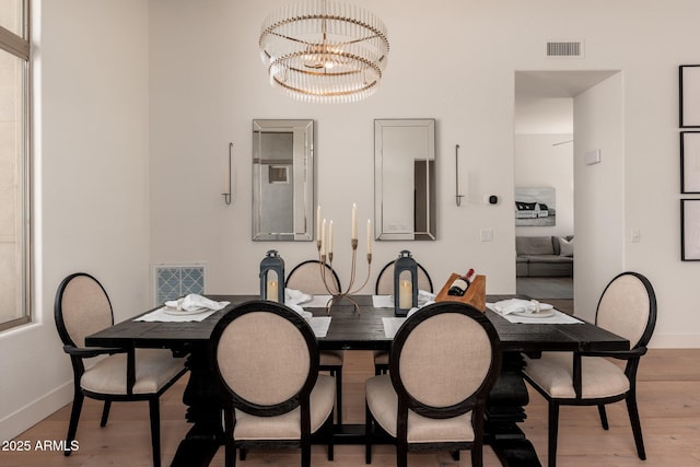 dining room with a chandelier, wood finished floors, and baseboards