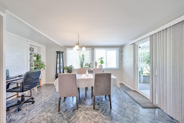 11815 N 112th Dr, Youngtown, AZ 85363 - dining space featuring brick wall, a chandelier, tile patterned floors, and ornamental molding