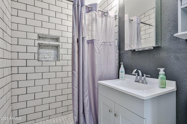 11815 N 112th Dr, Youngtown, AZ 85363 - bathroom with vanity, tiled shower, and a textured wall