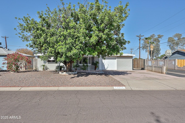 11815 N 112th Dr, Youngtown, AZ 85363 - view of property hidden behind natural elements featuring driveway, fence, and a garage