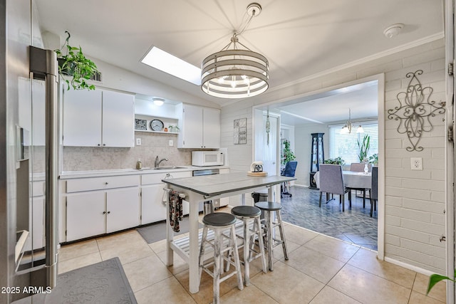 11815 N 112th Dr, Youngtown, AZ 85363 - kitchen featuring white microwave, a chandelier, a sink, open shelves, and vaulted ceiling