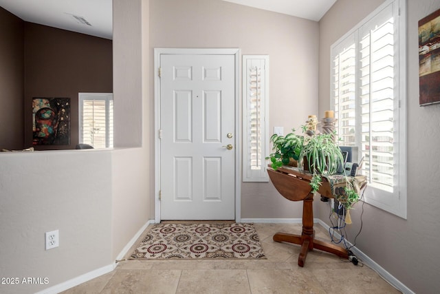 foyer featuring lofted ceiling and light tile patterned floors