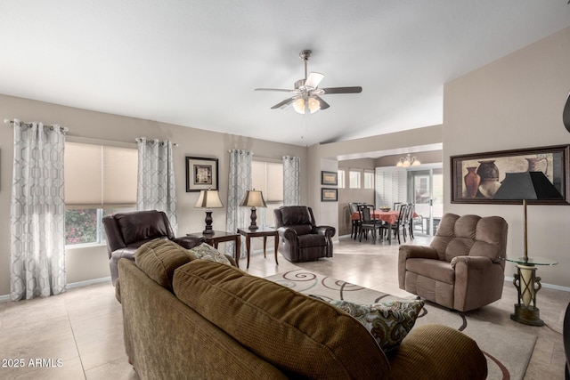 tiled living room featuring ceiling fan with notable chandelier and vaulted ceiling