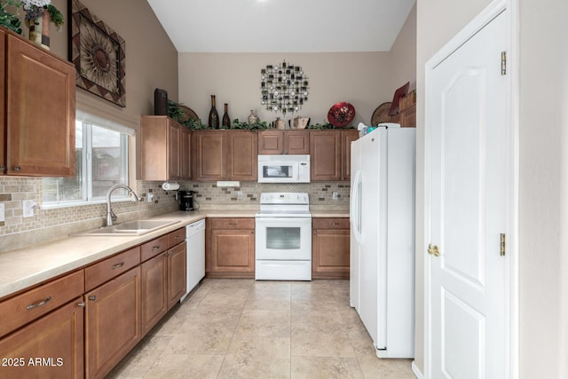 kitchen featuring sink, backsplash, and white appliances