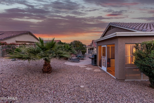 yard at dusk featuring a patio