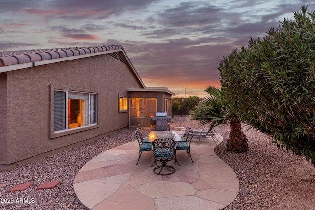 patio terrace at dusk featuring grilling area