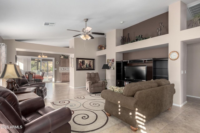 tiled living room featuring ceiling fan with notable chandelier