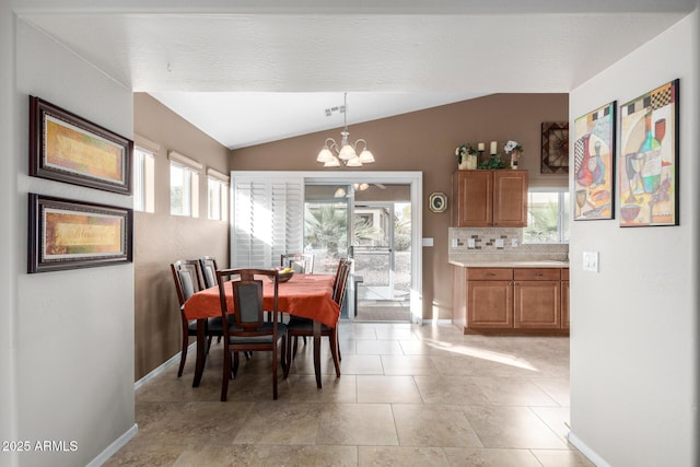 dining room featuring light tile patterned flooring, a wealth of natural light, a chandelier, and lofted ceiling