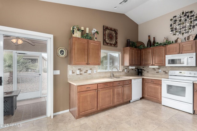 kitchen with sink, white appliances, backsplash, and lofted ceiling