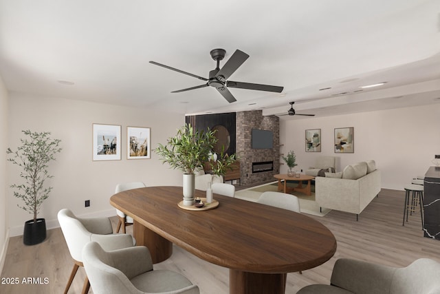 4019 E Surrey Ave, Phoenix, AZ 85032 - dining space featuring baseboards, a ceiling fan, a brick fireplace, and light wood finished floors