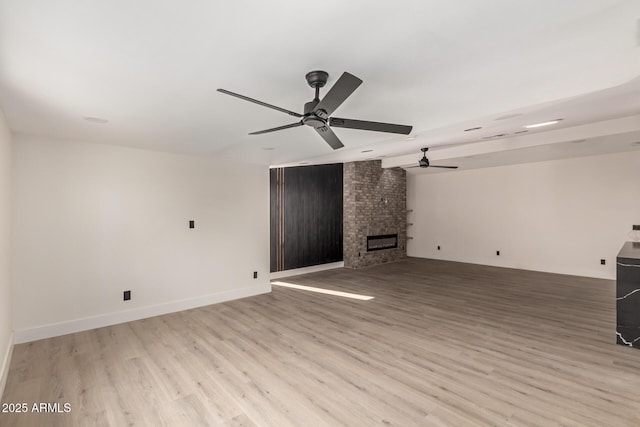 4019 E Surrey Ave, Phoenix, AZ 85032 - unfurnished living room featuring ceiling fan, light wood-type flooring, and a fireplace