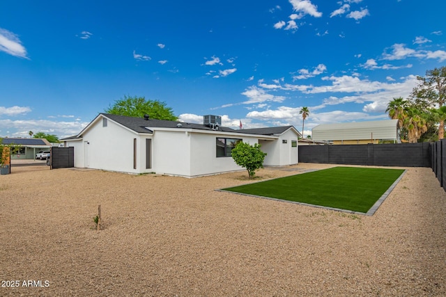 4019 E Surrey Ave, Phoenix, AZ 85032 - back of property featuring a fenced backyard, stucco siding, central AC unit, and a lawn