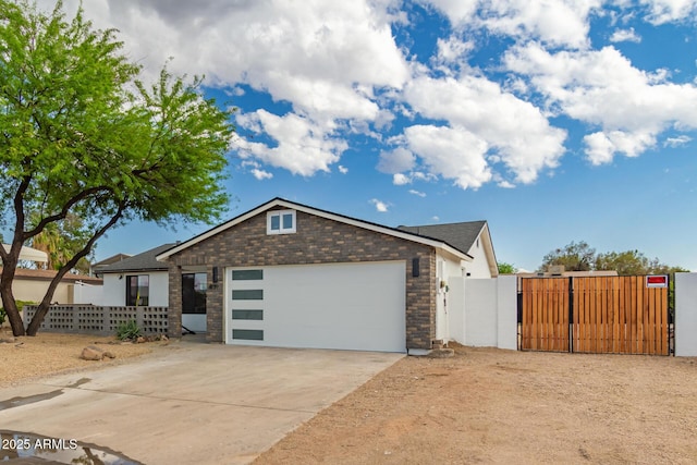 4019 E Surrey Ave, Phoenix, AZ 85032 - ranch-style house featuring concrete driveway, a gate, stone siding, an attached garage, and fence
