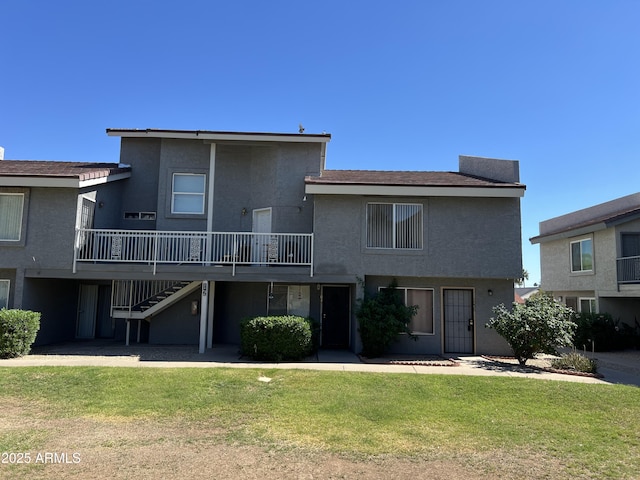 19601 N 7th St Ave Unit 1036, Phoenix, AZ 85024 - rear view of house with stairway, a lawn, stucco siding, and a deck