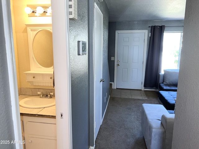 19601 N 7th St Ave Unit 1036, Phoenix, AZ 85024 - corridor featuring a sink, carpet flooring, a textured wall, and tile patterned flooring