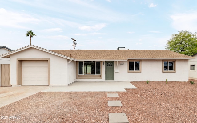 ranch-style home with a garage, driveway, stucco siding, and roof with shingles
