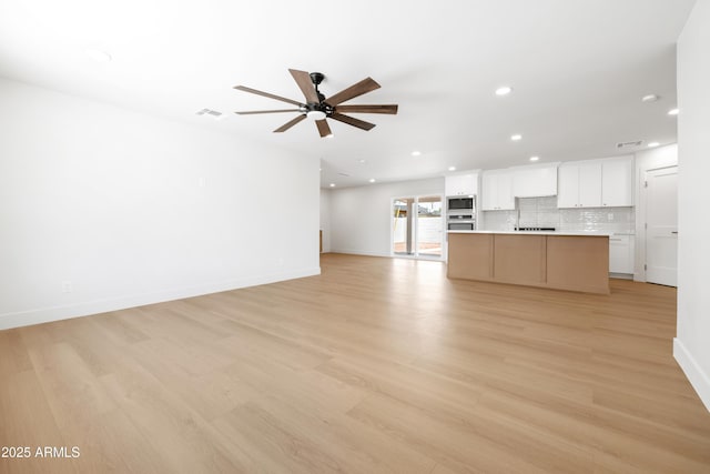 unfurnished living room with a ceiling fan, recessed lighting, light wood-type flooring, and baseboards