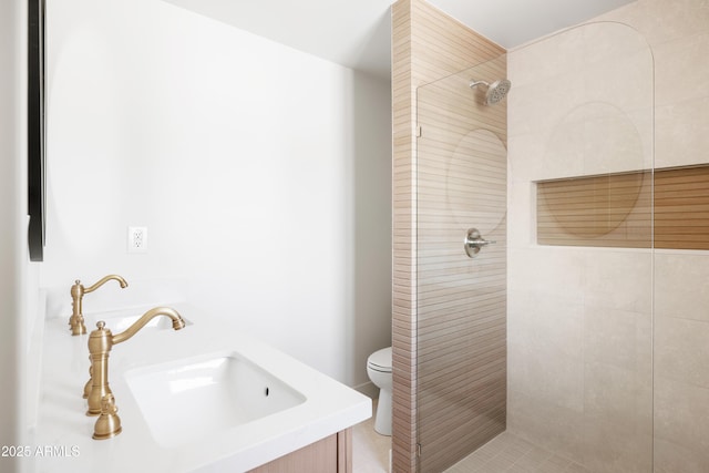 full bathroom featuring toilet, tiled shower, and vanity