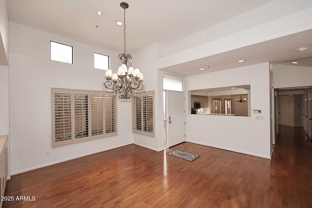 unfurnished dining area featuring an inviting chandelier and dark hardwood / wood-style floors