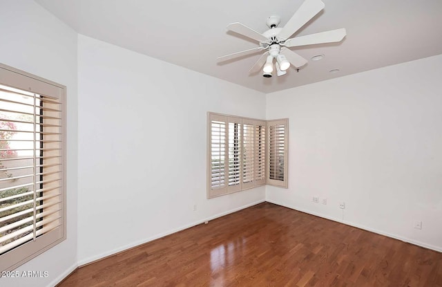 empty room with ceiling fan and dark hardwood / wood-style flooring